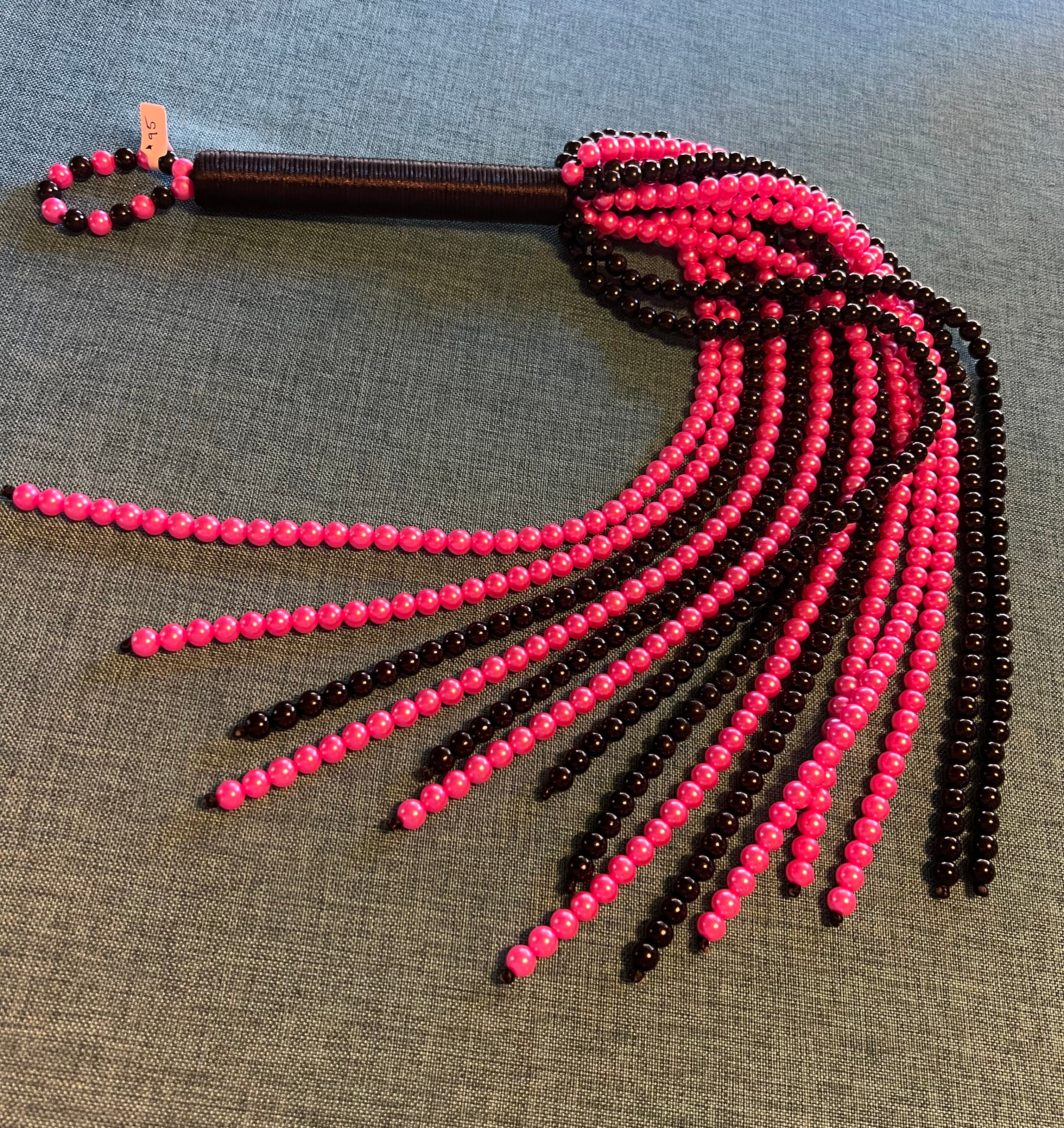 Pink and black beaded flogger